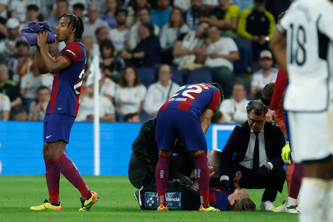 El centrocampista neerland&eacute;s del FC Barcelona Frenkie de Jong (abajo) es atendido por los servicios m&eacute;dicos en el estadio Santiago Bernab&eacute;u de Madrid en foto de archivo de Juanjo Mart&iacute;n. EFE