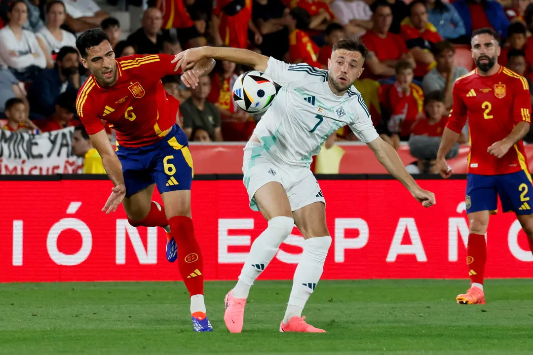 El centrocampista de la selecci&oacute;n espa&ntilde;ola Mikel Merino (i) pelea un bal&oacute;n con Conor McMenamin, de Irlanda del Norte, durante el partido amistoso de f&uacute;tbol disputado en el estadio de Son Moix. EFE/Cati Cladera