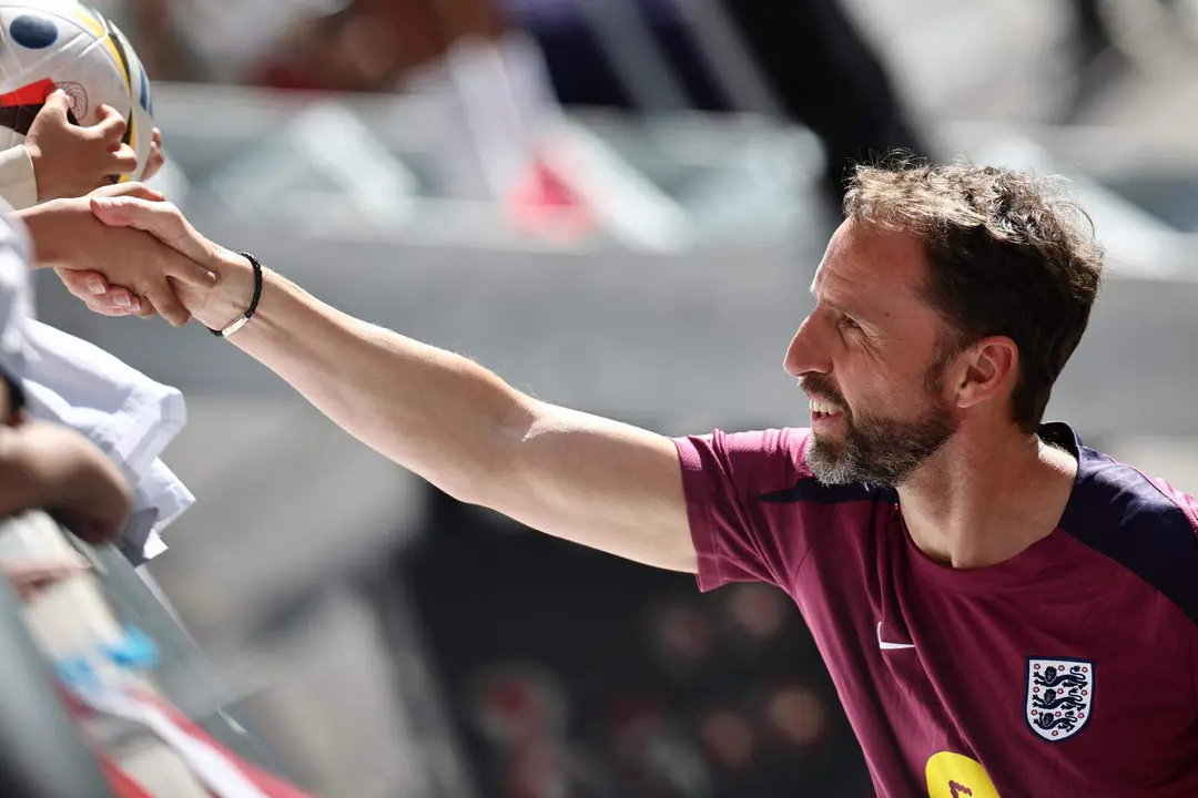 El entrenador ingl&eacute;s Gareth Southgate le da la mano a un aficionado despu&eacute;s de una sesi&oacute;n de entrenamiento abierta del equipo nacional de f&uacute;tbol ingl&eacute;s en Jena, Alemania. EFE/EPA/ANNA SZILAGYI