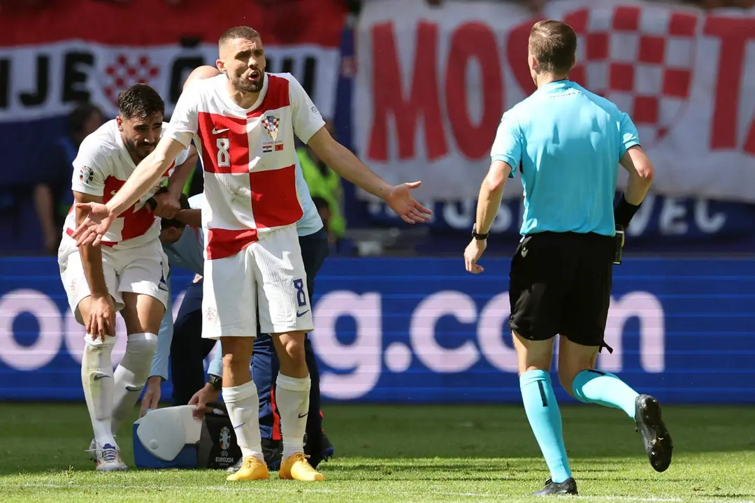 El croata Mateo Kovacic habla con el &aacute;rbitro Francois Letexier en Hamburgo, Alemania. EFE/EPA/ABEDIN TAHERKENAREH