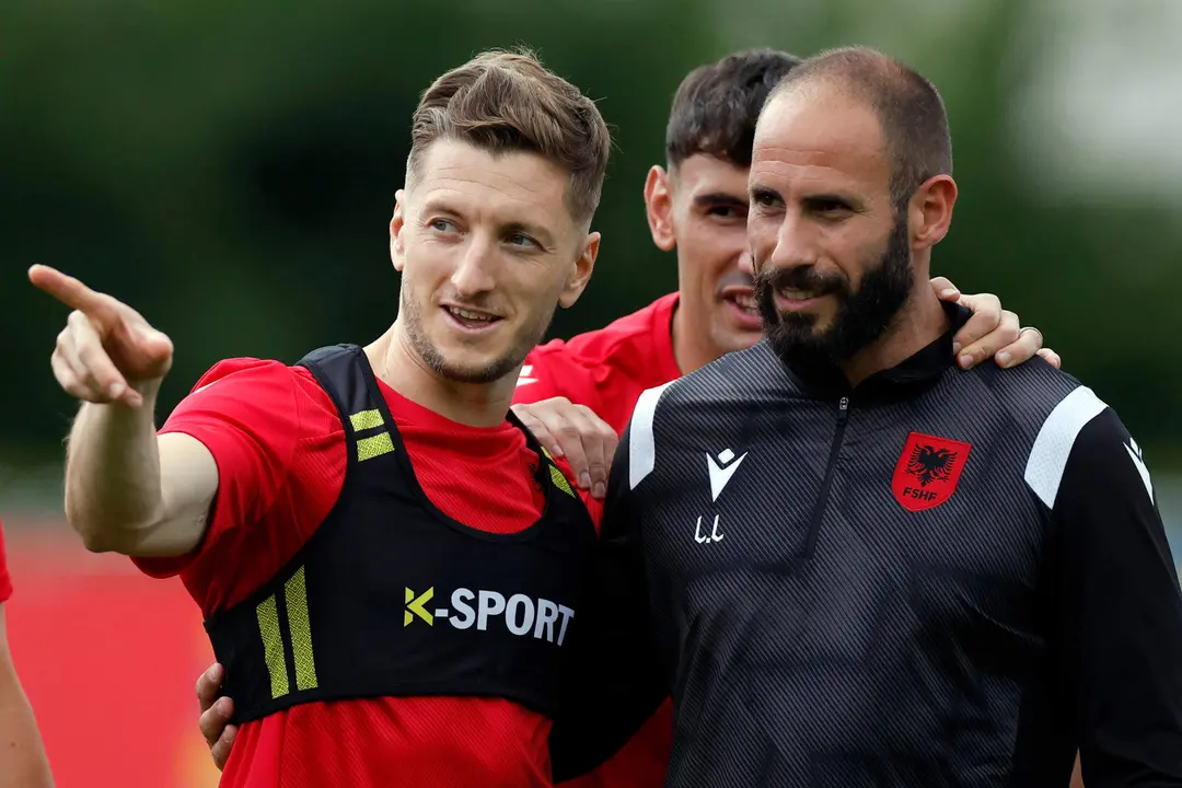 El jugador de Albania Iv&aacute;n Balliu (i) conversa con el preparador f&iacute;sico Luca Laurenti . EFE/Alberto Est&eacute;vez