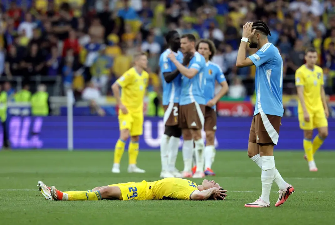El ucraniano Oleksandr Svatok (tendido en el c&eacute;sped) y varios jugadores belgas durante el  partido del grupo E que han jugado B&eacute;lgica y Ucrania en Stuttgart, Alemania. EFE/EPA/RONALD WITTEK