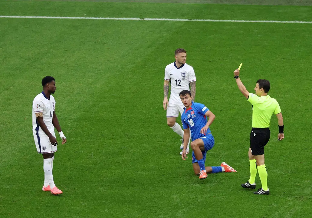 El &aacute;rbitro Umut Meler (d) muestra amarilla al defensa Marc Guehi durante el partido de octavos de final que han jugado Inglaterra y Eslovaquia en Gelsenkirchen, Alemania. EFE/EPA/GEORGI LICOVSKI