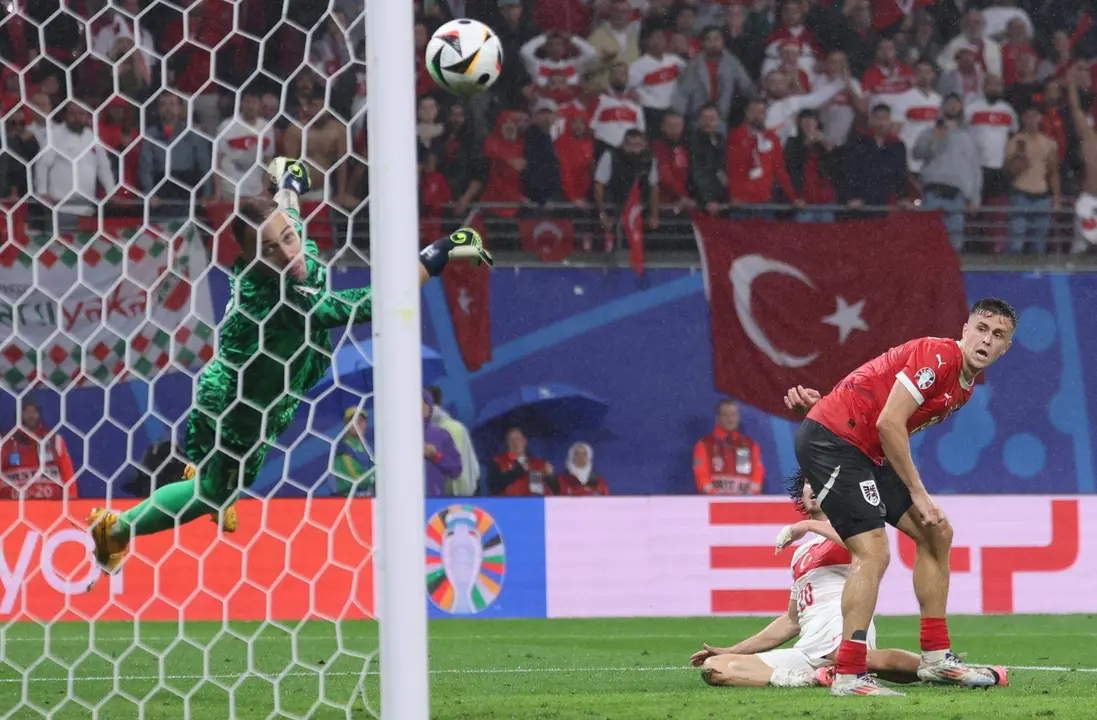 El portero turco Mert Gunok (i) salva un tiro de Christoph Baumgartner de Austria (d) durante el partido de f&uacute;tbol de la Eurocopa 2024. EFE/EPA/CHRISTOPHER NEUNDORF