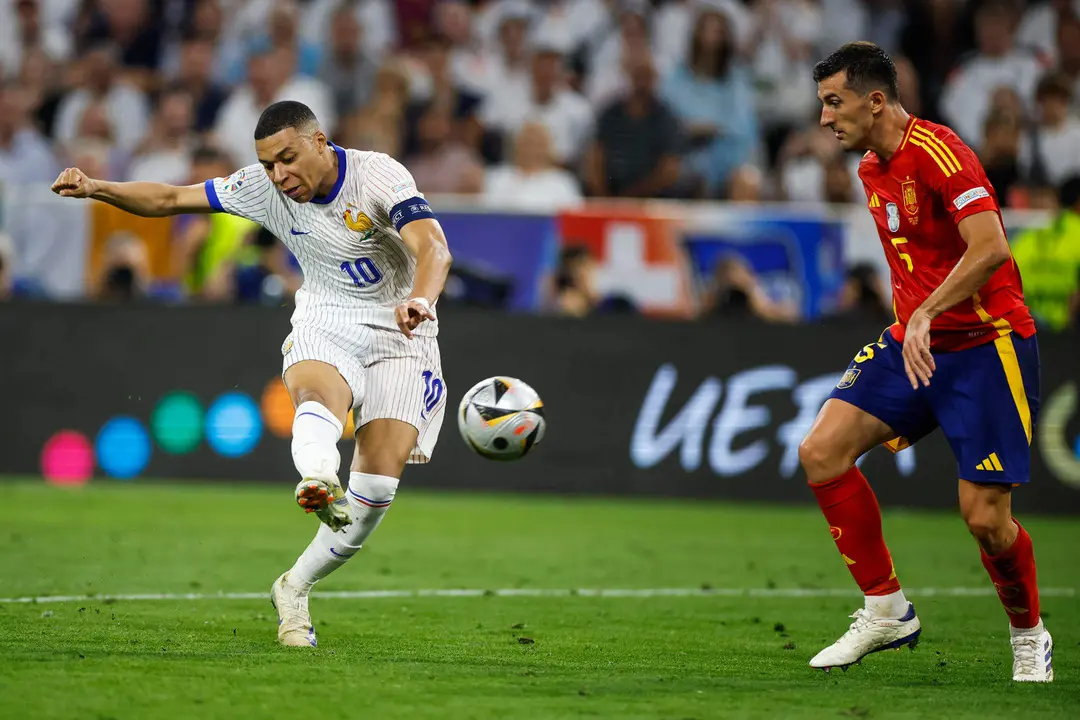 El delantero de la selecci&oacute;n francesa Kylian Mbapp&eacute; (i) chuta ante el espa&ntilde;ol Daniel Vivian, durante el partido de semifinales de la Eurocopa de f&uacute;tbol que Espa&ntilde;a y Francia disputan este martes en M&uacute;nich. EFE/Alberto Est&eacute;vez