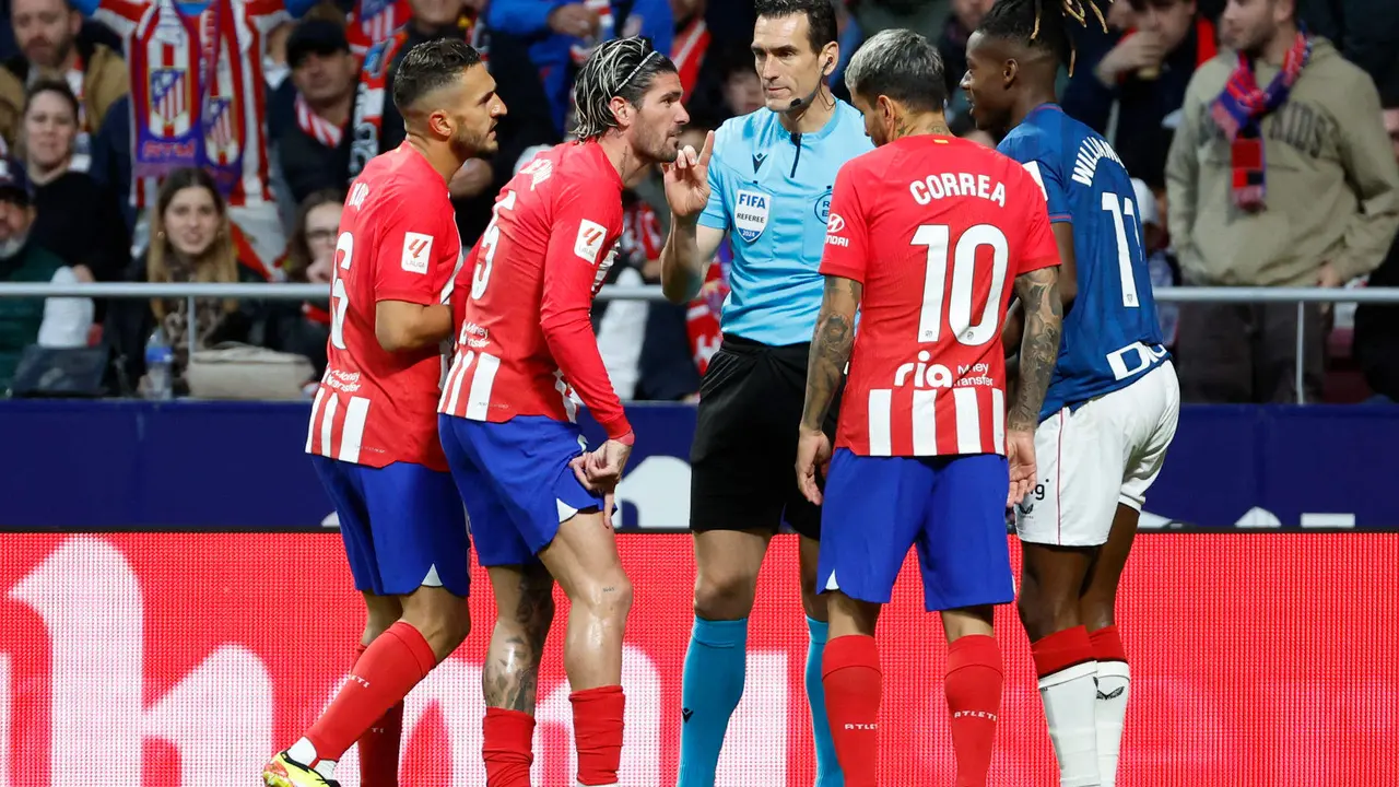 Jugadores del Atl&eacute;tico de Madrid conversan con el &aacute;rbitro Mart&iacute;nez Munuera durante un partido de la Liga espa&ntilde;ola. EFE/Mariscal