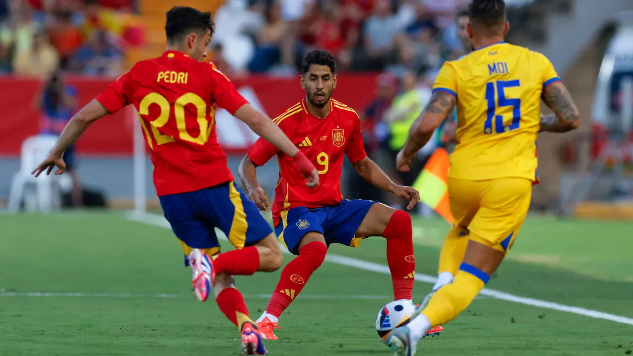 El defensa de la selecci&oacute;n andorrana de f&uacute;tbol Mois&eacute;s San Nicol&aacute;s (d) pelea un bal&oacute;n con Pedri (i) y Ayoze P&eacute;rez, ambos de Espa&ntilde;a, durante el partido amistoso que Espa&ntilde;a y Andorra disputan este mi&eacute;rcoles en el estadio Nuevo Vivero, en Badajoz. EFE/Julio Mu&ntilde;oz