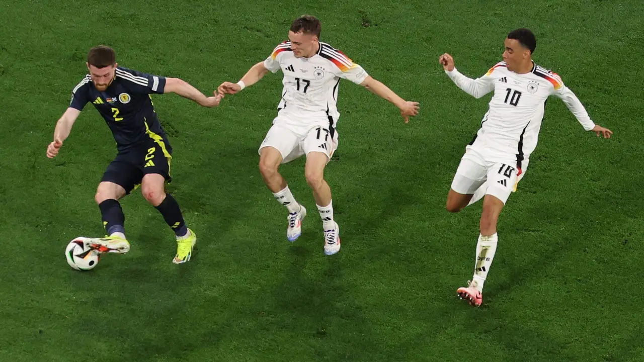 (i-d) El jugador escoc&eacute;s Anthony Ralston en acci&oacute;n contra los alemanes Florian Wirtz y Jamal Musiala de Alemania durante el partido de la Eurocopa 2024 entre Alemania y Escocia en Munich, Alemania. EFE/EPA/MOHAMED MESSARA