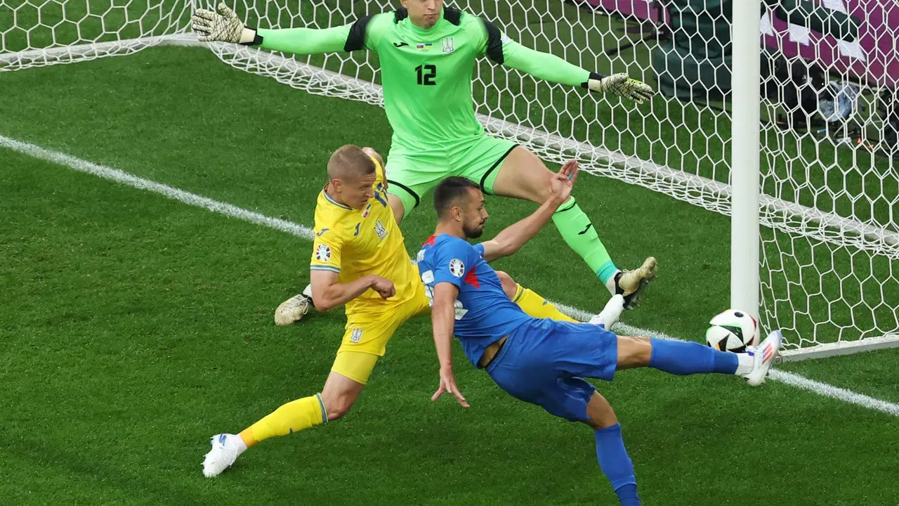 El jugador de Eslovaquia Ivan Schranz (d) logra el gol ante Ucrania al superar al portero ucraniano Anatolii Trubin (top) durante el partido del grupo E que jugaron Eslovaquia y Ucrania en D&uuml;sseldorf, Alemania. EFE/EPA/FRIEDEMANN VOGEL