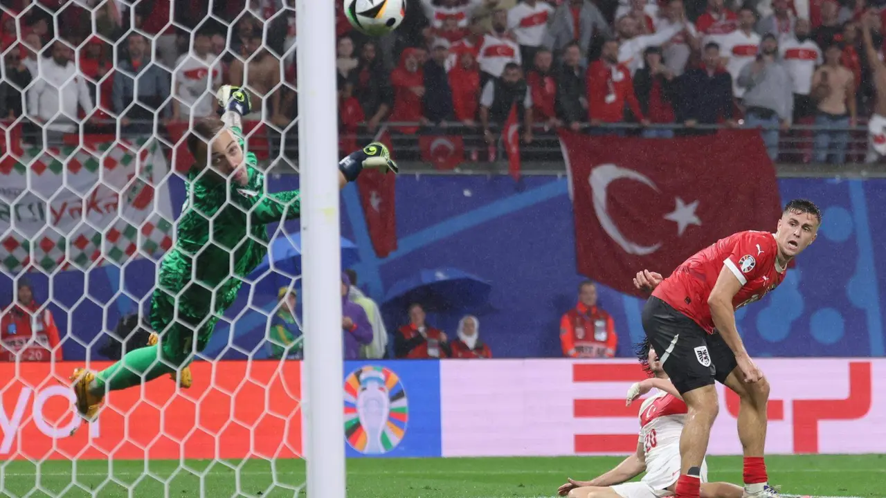 El portero turco Mert Gunok (i) salva un tiro de Christoph Baumgartner de Austria (d) durante el partido de f&uacute;tbol de la Eurocopa 2024. EFE/EPA/CHRISTOPHER NEUNDORF