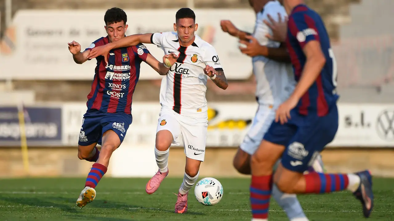 El centrocampista colombiano del RCD Mallorca Daniel Luna (2i) se escapa del defensa de la UD Poblense, durante el partido amistoso de f&uacute;tbol que UD Poblense y RCD Mallorca disputan este mi&eacute;rcoles en Sa Pobla. EFE/MIQUEL A. BORR&Agrave;S